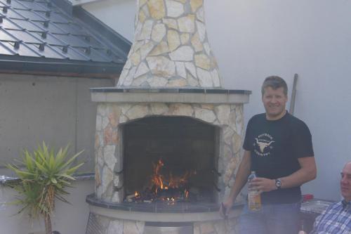 a man standing in front of a stone fireplace at Sport Garni Kapplerhof – Ischgl/Kappl in Kappl
