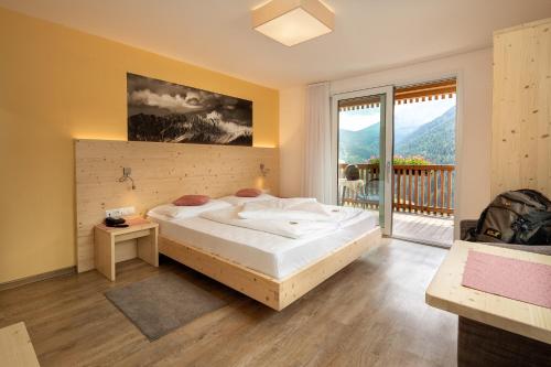 una camera da letto con un letto grande e un balcone di Mounthotel Niggl a Nova Levante