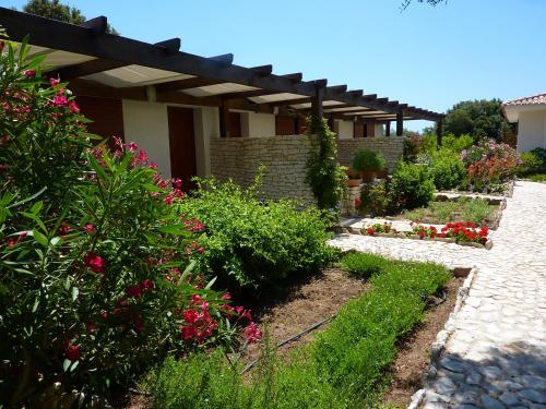 a garden with pink flowers and a pergola at Poisson Rouge in Bonifacio