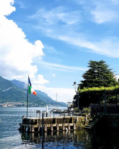a flag flying next to a dock on a body of water at La Turr de Mezz- Bellagio LCA in Bellagio