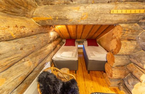 a room with two beds in a log cabin at Kuukkeli Apartments Pikku-Hirvas ja Porotokka in Saariselka