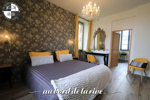 a bedroom with a bed and a table and a mirror at Au Bord de la Rive B&B in Pontrieux