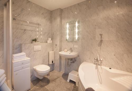 a bathroom with a sink and a toilet and a tub at Heidelberg Apheartments in Heidelberg