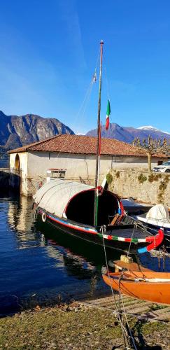 a boat is docked in the water next to a building at La Turr de Mezz- Bellagio LCA in Bellagio