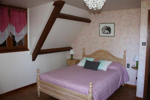 1 dormitorio con 1 cama con manta morada en GRAND GITE RURAL, en Salmiech