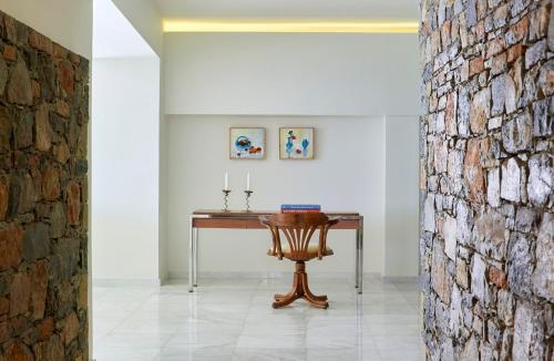 a table in a room with a brick wall at St. Nicolas Bay Resort Hotel & Villas in Agios Nikolaos