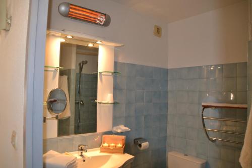 une salle de bain avec un lavabo et un miroir et des toilettes dans l'établissement Le California Motel, à Sagone