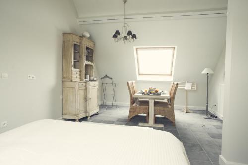 um quarto com uma mesa e cadeiras e uma cama em B&B In de velden em Bocholt