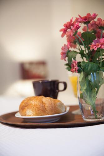 a plate of bread on a table with a vase of flowers at Heidelberg Apheartments in Heidelberg