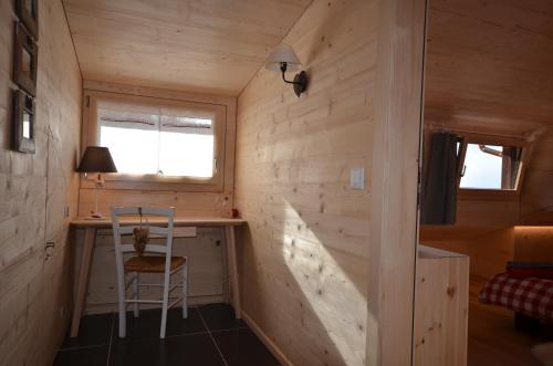a tiny house with a desk and a chair at Chalet Rouge Coeur in Fenalet Sur Bex