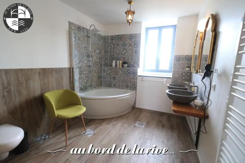 a bathroom with a tub and a sink at Au Bord de la Rive B&B in Pontrieux