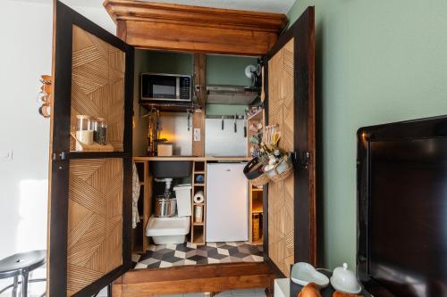 une petite cuisine avec une porte ouverte sur une pièce dans l'établissement Studio - Les villas du triangle, à Nîmes