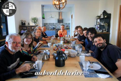 a group of people sitting around a table at Au Bord de la Rive B&B in Pontrieux