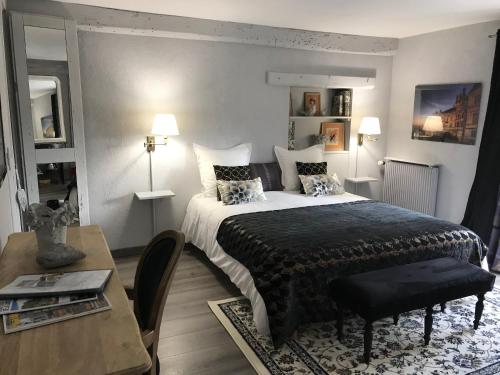 a bedroom with a large bed and a table with a table at La Levraudière in Cheverny