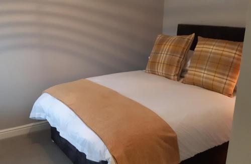 a bedroom with a bed with a brown and white blanket at The Masons Arms in Harrogate