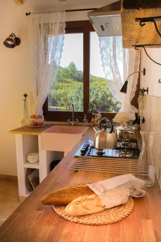 a kitchen with a counter with a stove and a window at Can Elisa in Tárbena