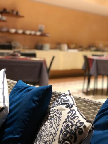 a couch with blue and white pillows on it at Hotel Serena in Rieti