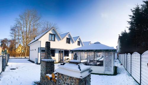a house with a fence in the snow at Tu Urlop in Mielno