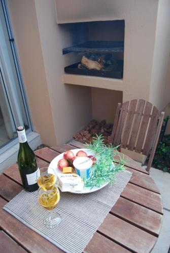a table with a plate of apples and a bottle of wine at The Lofts in Polokwane