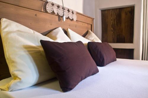 a bed with four pillows on top of it at Contrada Beltramelli in Villa di Tirano