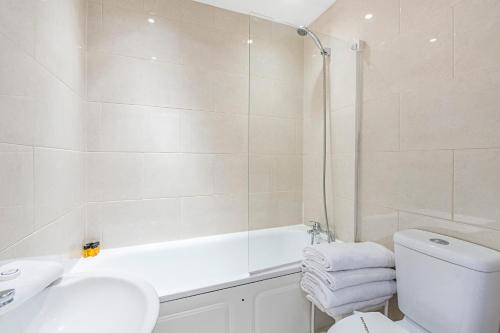 a bathroom with a shower and a toilet and a sink at Knightsbridge Dream Apartment in London