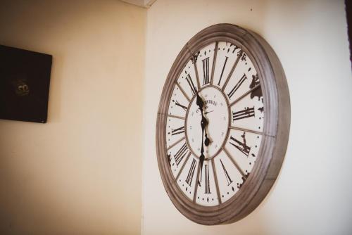 Eine Uhr hängt an einer Wand in der Unterkunft Hotel Le Flore in Fréjus