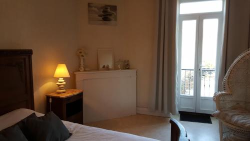 ein Schlafzimmer mit einem Bett, einem Fenster und einer Lampe in der Unterkunft Gîte 5 personnes in Fleurville