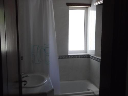 a bathroom with a shower and a sink and a window at Hotel Minho Belo in Vila Nova de Cerveira