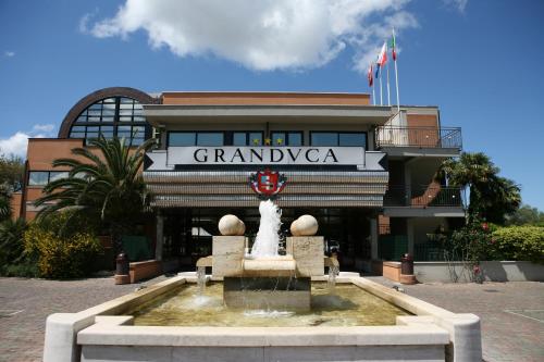 a building with a fountain in front of a building at Hotel Granduca SPA & Parking in Grosseto