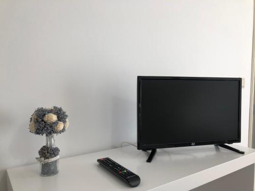 a television sitting on a table with a remote control at Casa da Retorta in Alcains