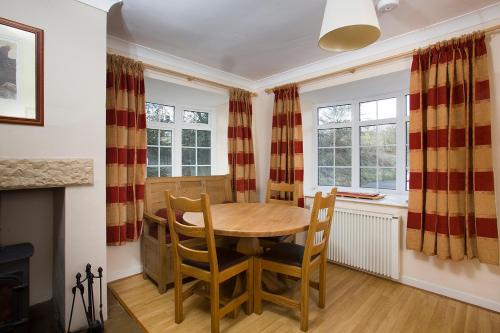 a dining room with a table and chairs and a fireplace at Stable Cottage in Bardon Mill
