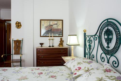 a bedroom with a bed and a dresser at Elegant Sea View Apartment in Nazaré