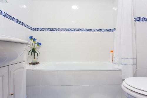 a white bathroom with a white tub and a toilet at Elegant Sea View Apartment in Nazaré