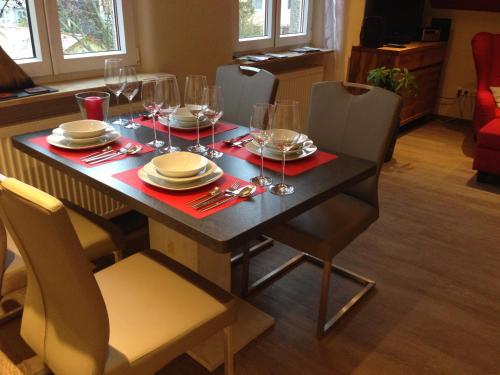 a dining table with wine glasses and plates on it at CasaNova in Bad Windsheim
