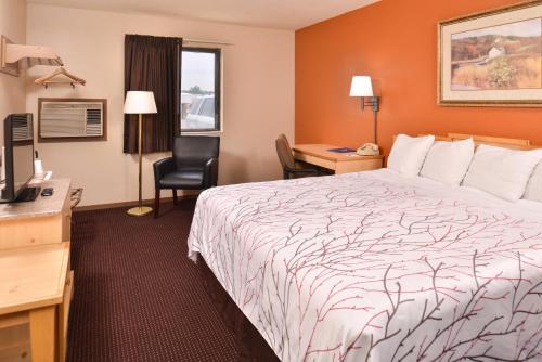 a hotel room with a bed and a desk at Cottonwood Inn and Conference Center in South Sioux City