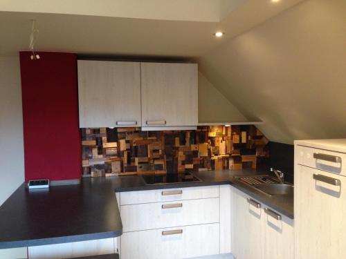 a kitchen with white cabinets and a black counter top at CasaNova in Bad Windsheim