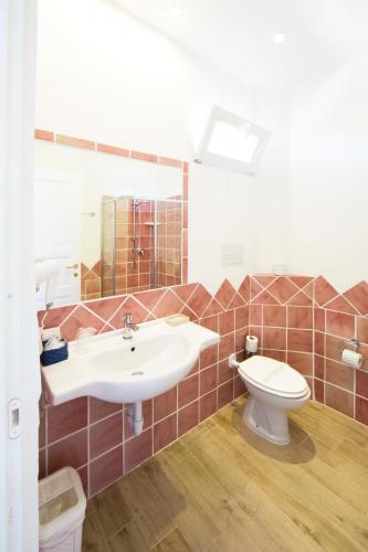 a bathroom with a sink and a toilet at Grand Hotel Palau in Palau