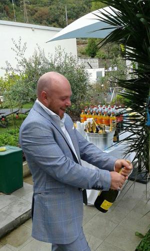 a man in a suit holding a bottle at Levante Residence in La Spezia
