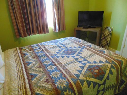 a bedroom with a quilt on a bed with a television at Bryce Canyon Resort in Bryce Canyon