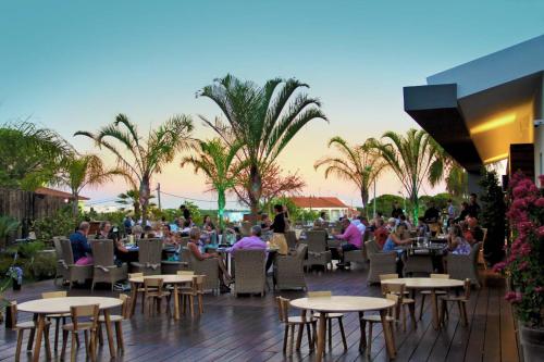 a group of people sitting at tables on a patio at Luxury 3 Bedroom Apartment on Gated Complex in Quarteira