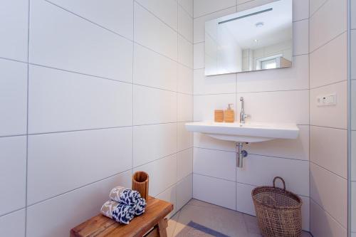 ein weißes Badezimmer mit einem Waschbecken und einem Spiegel in der Unterkunft Domein Groot Besselink | Studio in Almen