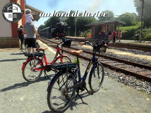Dos bicicletas están estacionadas junto a una estación de tren. en Au Bord de la Rive B&B, en Pontrieux