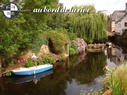 a man in a boat on a river with flowers at Au Bord de la Rive B&B in Pontrieux