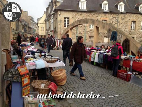 a man walking past an outdoor market in a street at Au Bord de la Rive B&B in Pontrieux