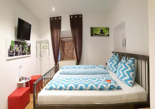 Schlafzimmer mit einem Bett mit blauen und weißen Kissen in der Unterkunft Hoamatl in Ebbs