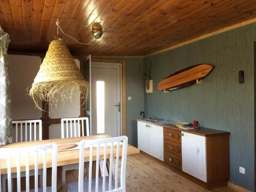 a kitchen with a table and a surfboard on the wall at Pfahlbau in Weiden am See in Weiden am See