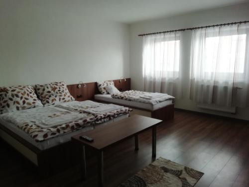 a living room with two beds and a coffee table at Motorest U Kola in Prostějov