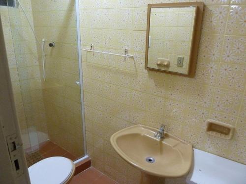 a bathroom with a sink and a toilet and a mirror at Casa de praia in São Pedro da Aldeia