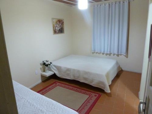 a small bedroom with two beds and a window at Casa de praia in São Pedro da Aldeia