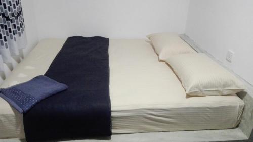 a white bed with a blue tie on it at Mango Roots in Gampaha